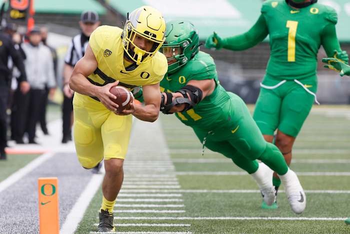 Travis Dye dives for the end zone as Isaac Slade-Matautia (41) tries to bring him down in Oregon's 2021 spring football game.